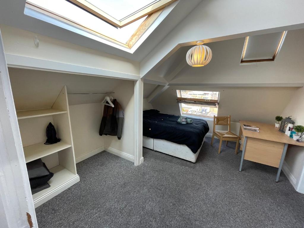 a bedroom with a bed and a desk and a skylight at Cosy Room in city centre in Newcastle upon Tyne