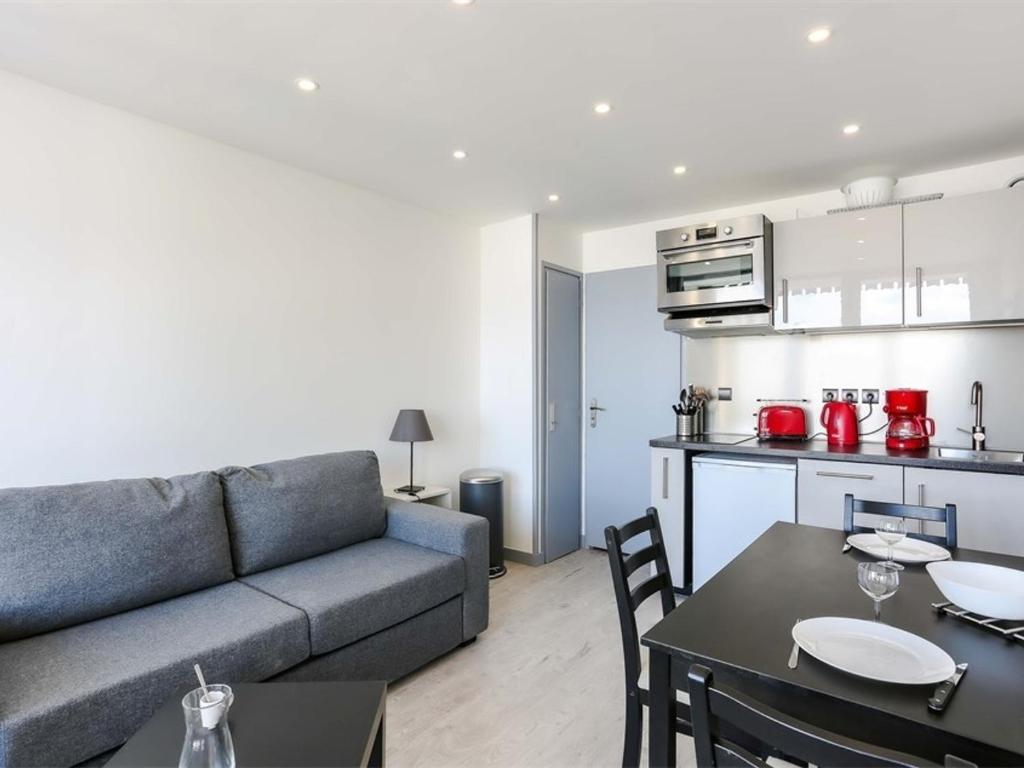 un salon avec un canapé et une table et une cuisine dans l'établissement Studio rénové avec balcon, centre Val Thorens, proche pistes, 2 pers, 3 Flocons Argent - FR-1-637-26, à Val Thorens