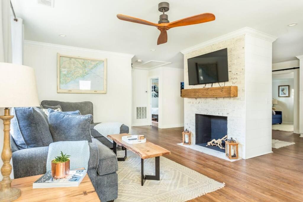 Una sala de estar con un sofá y una chimenea. en Open and Comfy home near Downtown-Folly Beach, en Charleston