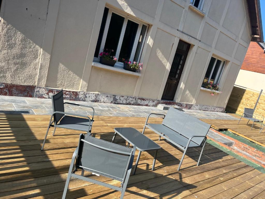 a group of chairs and tables on a deck at Chez Mélanie, près de l’abbaye in Jumièges