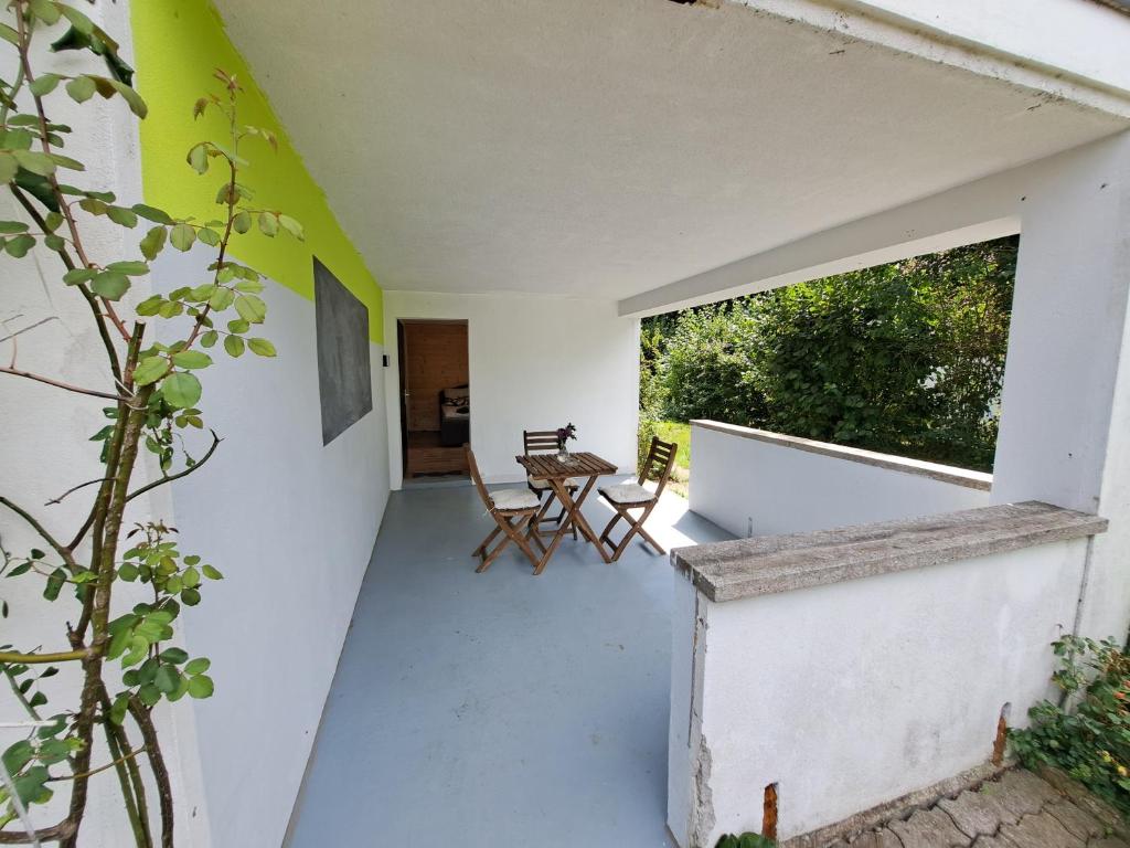 een kamer met een balkon met een tafel en stoelen bij Romantischer studio mit grosser Terrasse in Salavaux