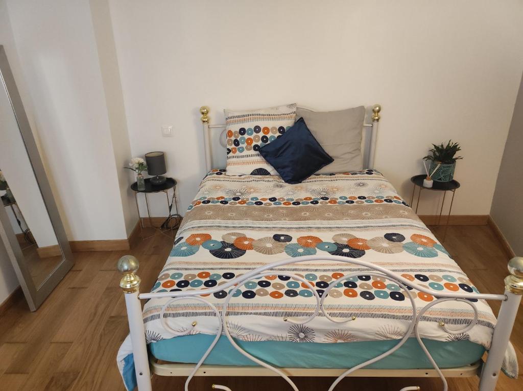 een slaapkamer met een bed met een sprei erop bij Magnifique maison Dans un village du Vexin in Ableiges