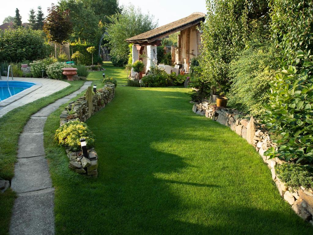 een tuin met groen gras en een hek en een huis bij Ubytování BŘECLAV in Břeclav