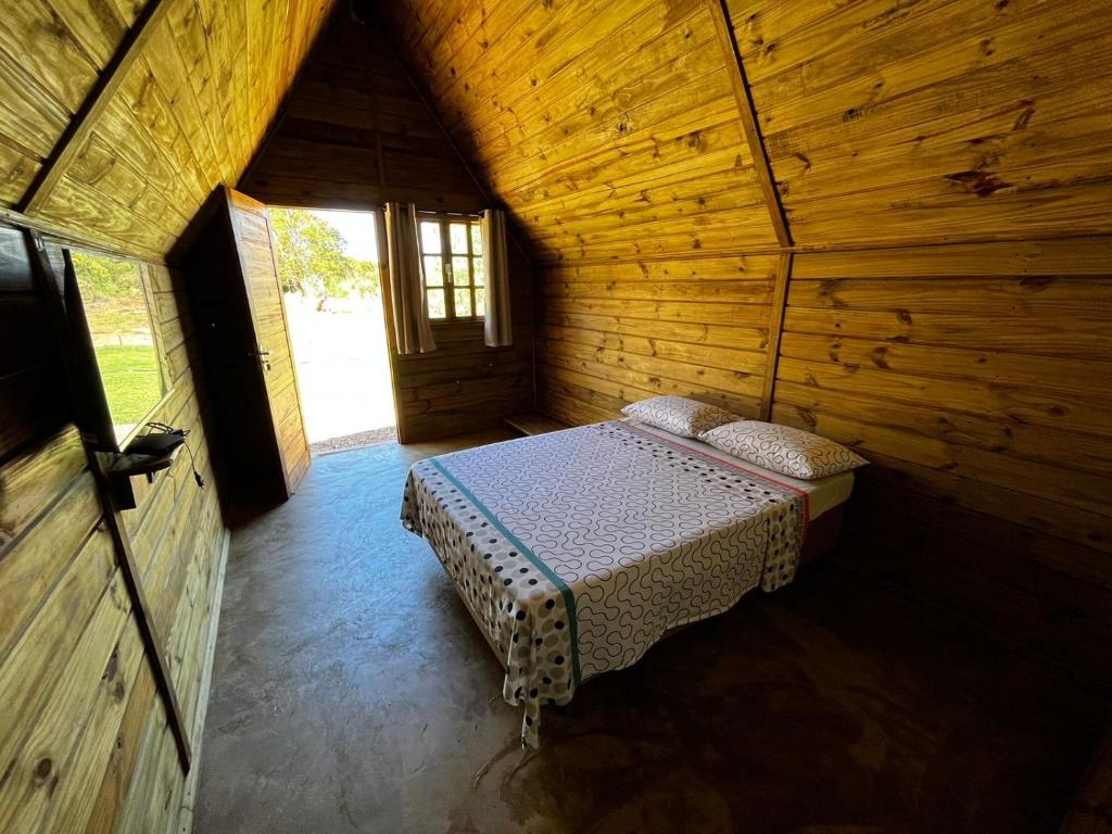 a room with a bed in a wooden cabin at Pousada Sossego do Tocantins in Lajeado