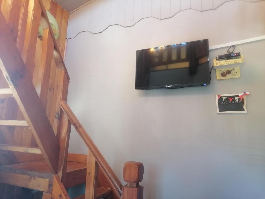TV de pantalla plana colgada en la pared en Habitación tipo Loft de la Estancia en El Quisco