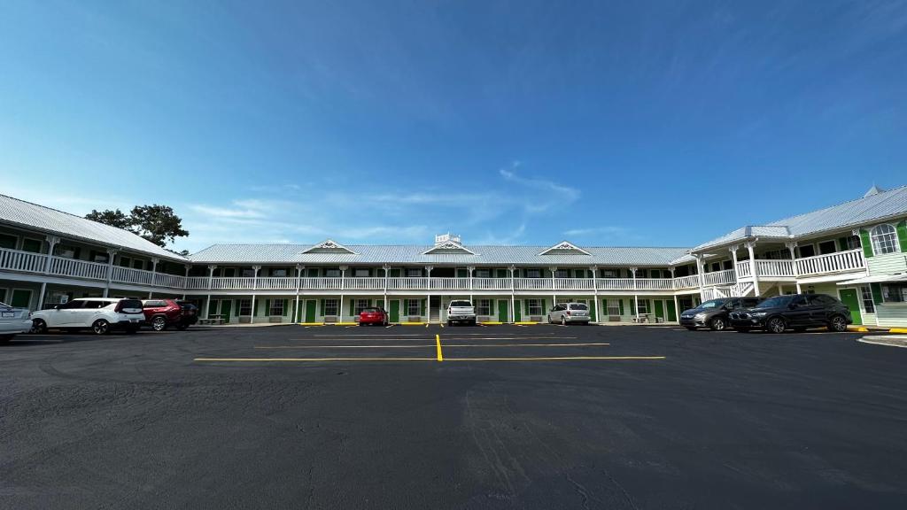 a large building with cars parked in a parking lot at Key West Inn - Chatsworth in Chatsworth