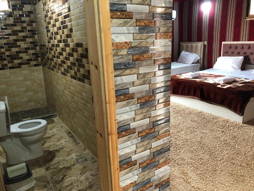 a bathroom with a brick wall and a toilet at Mira luxury camp in Wadi Rum