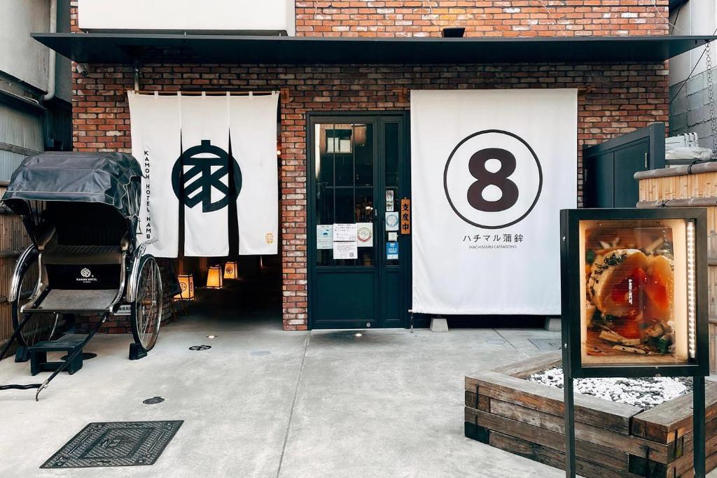 a brick building with a door with the number eight at Kamon Hotel Namba in Osaka