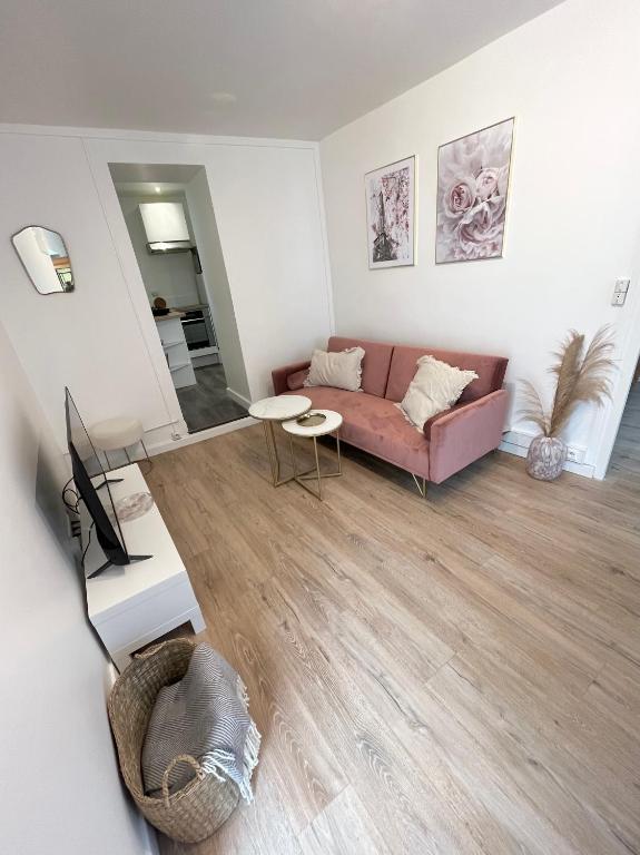 un salon avec un canapé et une table dans l'établissement Maisonnette à la campagne avec jardinet, à Ennery