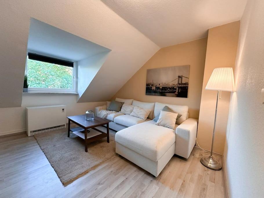 un soggiorno con un divano bianco e un tavolo di Zentrale Wohnung für 4 mit Bett und Schlafcouch a Essen