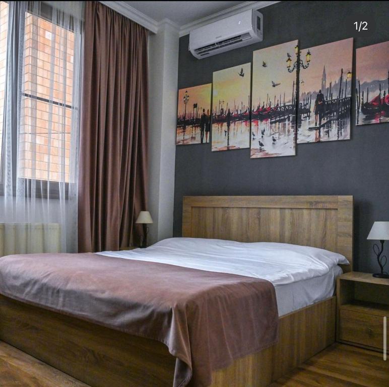 a bedroom with a bed with paintings on the wall at Sofia Hotel in Yerevan