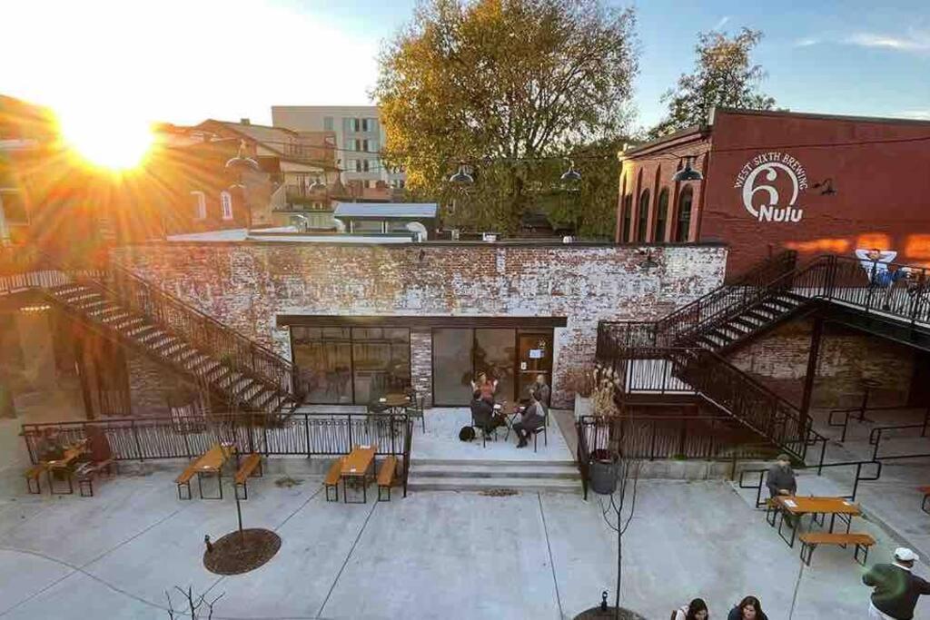 a group of people sitting outside of a building at 2Br Unit W/ Cinema Room in Nulu in Louisville