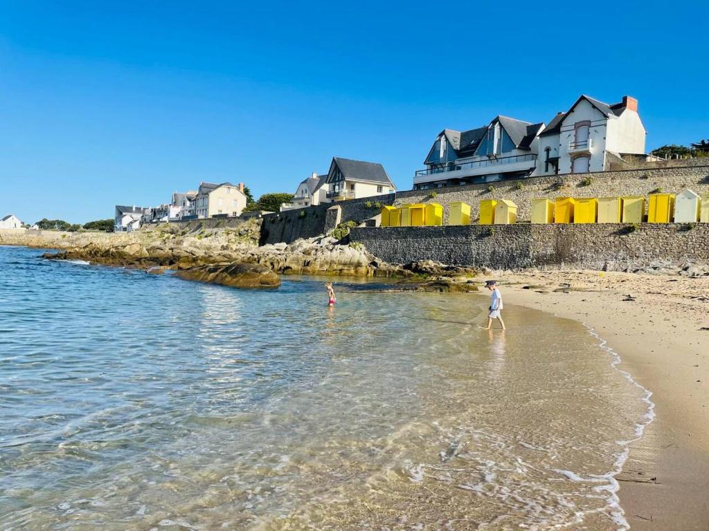 una persona in piedi sull'acqua di una spiaggia di Maisonnette à Batz sur Mer centre 8min des plages à pieds a Batz-sur-Mer