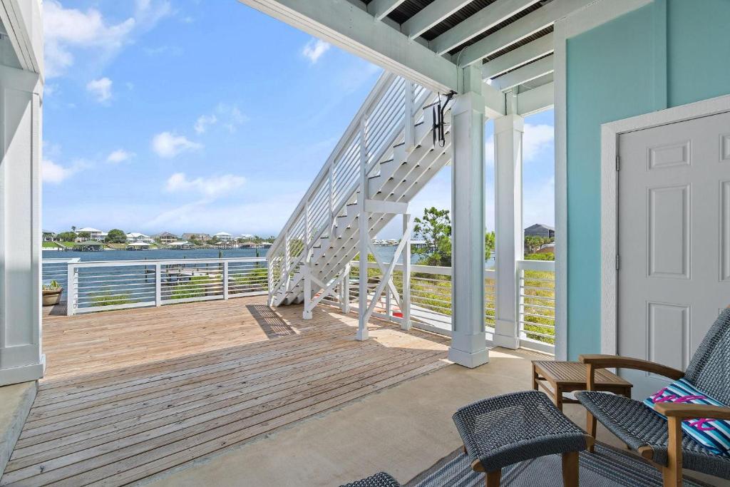a porch with a white staircase and a view of the water at Pescador Landing 6A in Pensacola