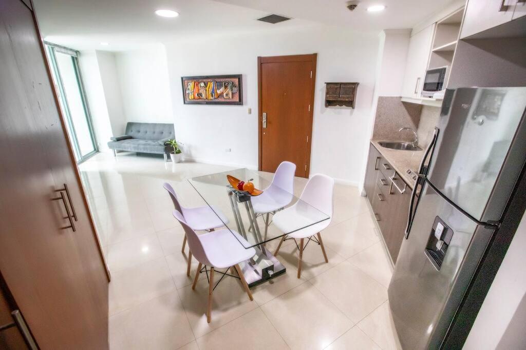 een keuken met een tafel en stoelen en een koelkast bij Suite Vista al río con Balcón en puerto Santa Ana in Guayaquil