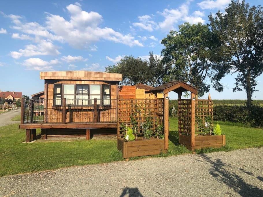 a tiny house with a gate and a garden at Couple’s Lodge With Hot Tub in Lincolnshire