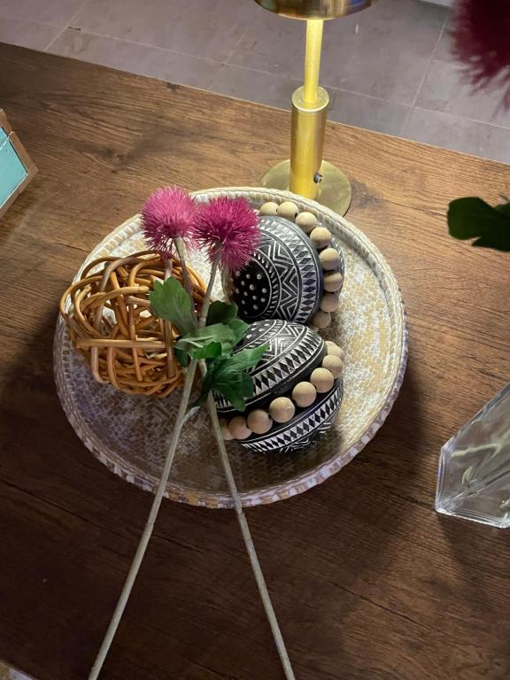 a table with a plate with a vase and a basket at استديو عائلي بمدخل خاص ودخول ذاتي in Riyadh Al Khabra