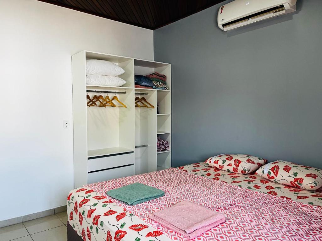 um quarto com uma cama e um armário com sapatos em Casa aconchegante com piscina em Macapá