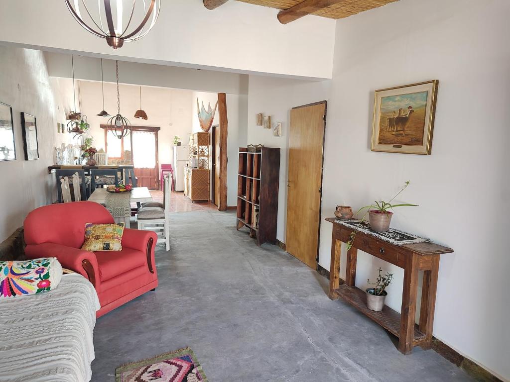 a living room with a red couch and a table at El Cobijo del Artista - en Huacalera in Huacalera
