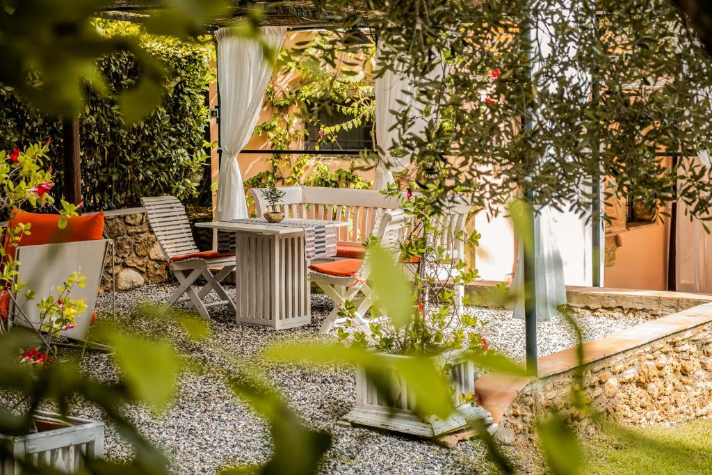 a patio with a table and chairs and plants at MONOLOCALE CASENUOVE con GIARDINO in Castiglioncello