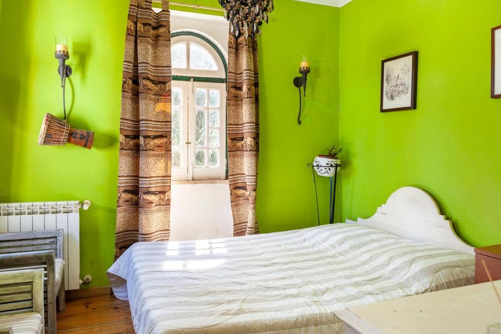 a bedroom with green walls and a white bed at B&B Quarto Verde Estilo Africano 