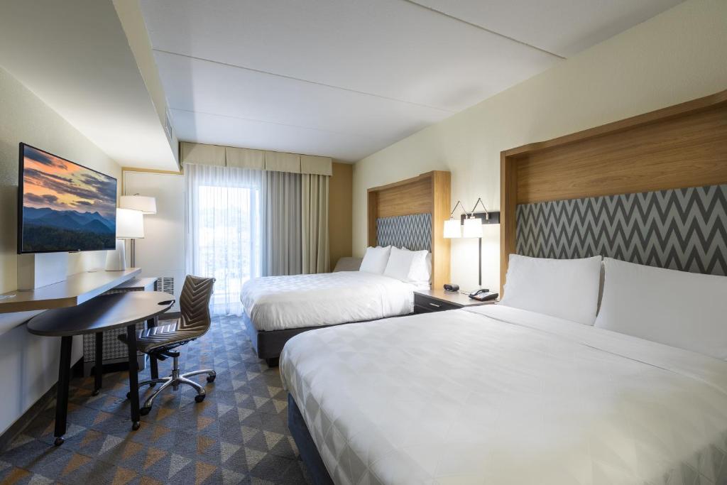 a hotel room with two beds and a desk at The Scenic Hotel at Biltmore Village in Asheville