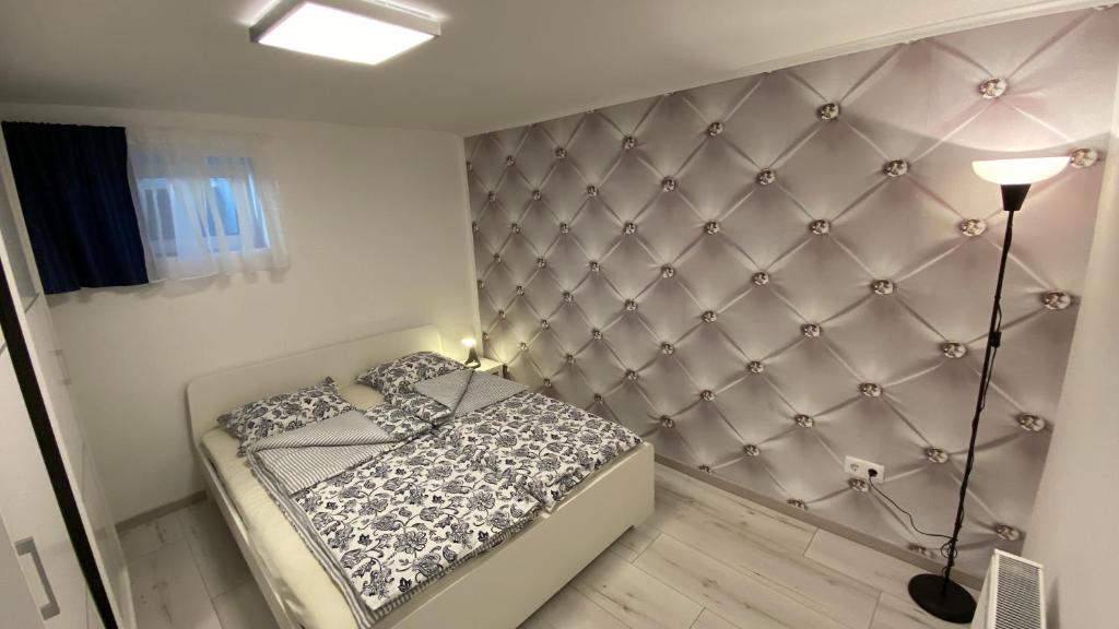 Schlafzimmer mit einem Bett mit gepolsterter Wand in der Unterkunft Diamond House in Veresegyház