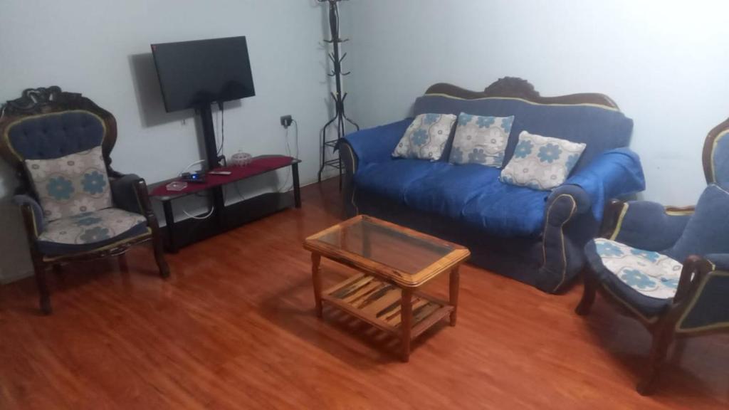 a living room with a blue couch and chairs at Casa Coyhaique in Coihaique