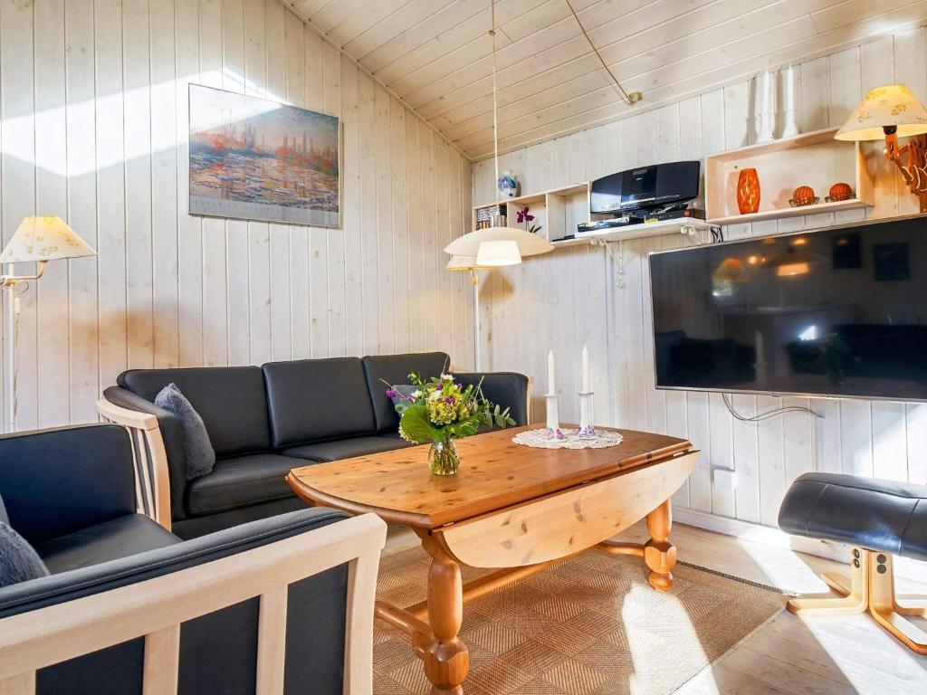 een woonkamer met een tafel en een bank bij 8 person holiday home in Nex in Vester Sømarken