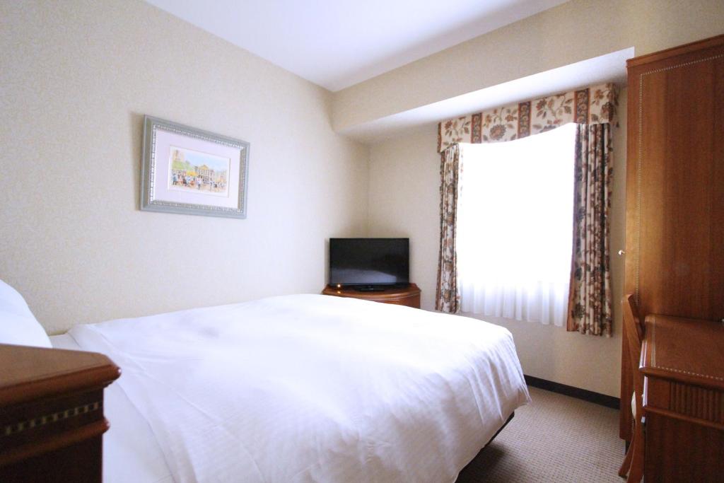Postel nebo postele na pokoji v ubytování KOKO HOTEL Nagoya Sakae