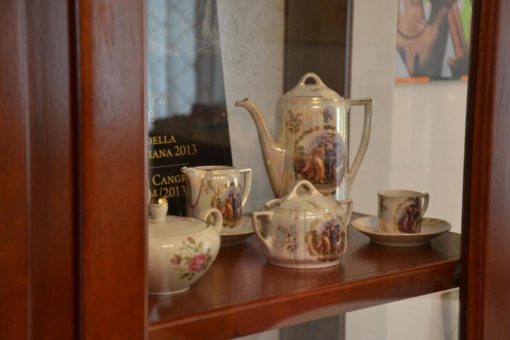 a shelf with a tea pot and cups on it at B&B Torre Porta Marina in Ventimiglia