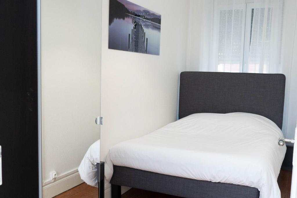 Beau T2 quartier Contades في ستراسبورغ: غرفة نوم بسرير ذو شراشف بيضاء