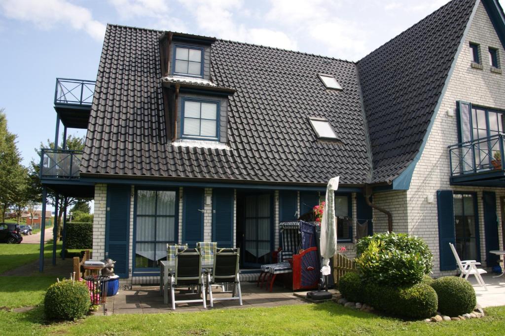 une maison bleue avec un toit noir dans l'établissement Ostseewelle, à Schönberger Strand