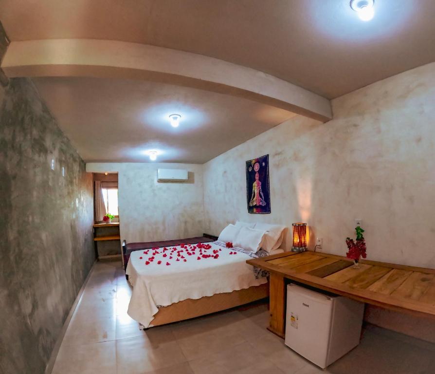 a bedroom with a bed with red roses on it at Pousada Ksa Zen Jeri in Jericoacoara