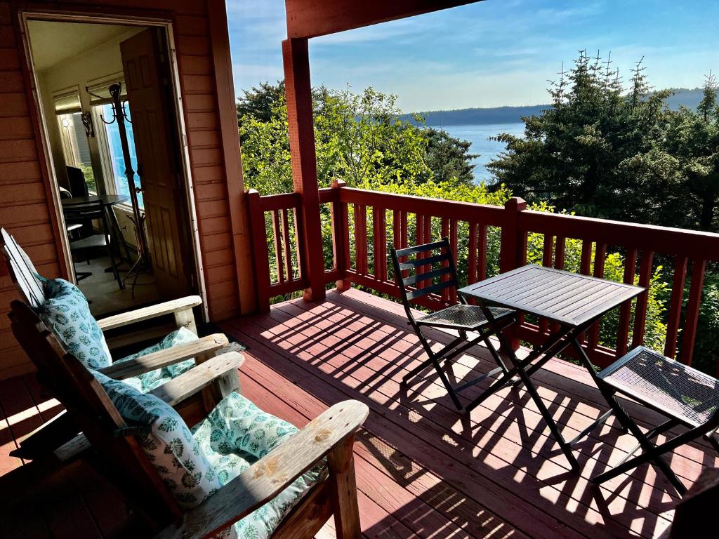 mecedora y mesa en un porche con vistas en The Peregrine Suite - Comfort and Luxury in the Heart of Kodiak, en Kodiak