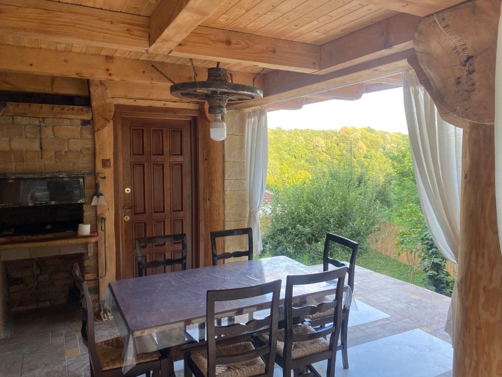 een eetkamer met een tafel en stoelen en een raam bij Casa cu șindrilă in Vălenii de Munte