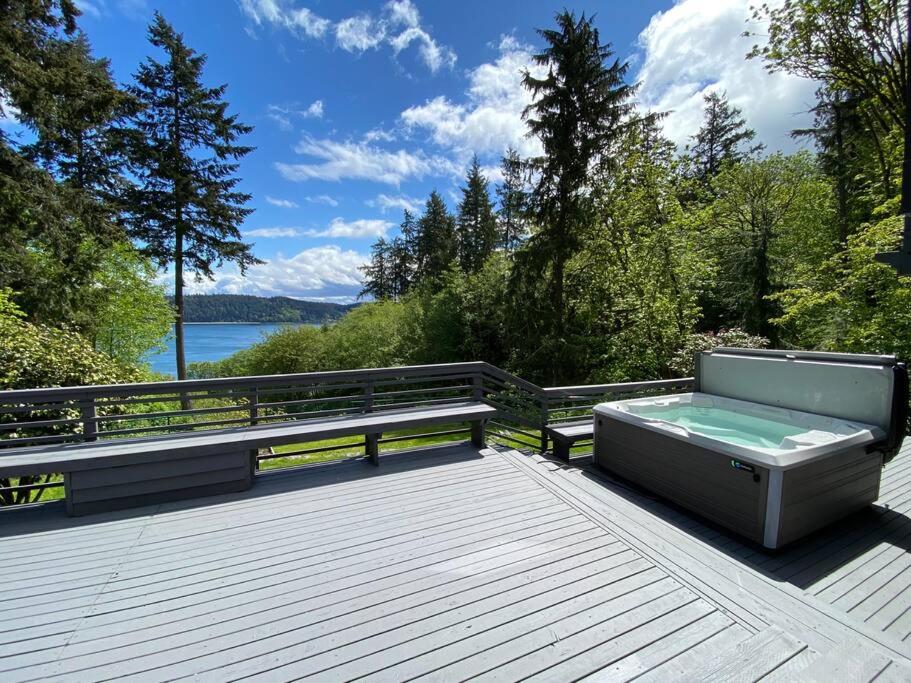 a hot tub sitting on top of a wooden deck at Secluded Sanctuary With a View of The Puget Sound in Gig Harbor