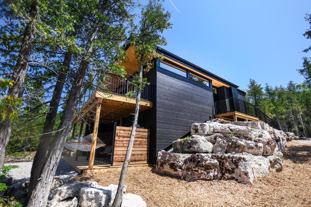 a modern cabin in the woods with a rock at Evo Luxury Waterfront Adults Only B&B in Tobermory