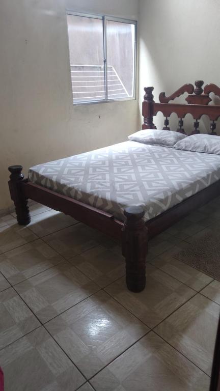 1 cama en un dormitorio con marco de madera en próx da UFOPA BEM LOCALIZADO, en Santarém