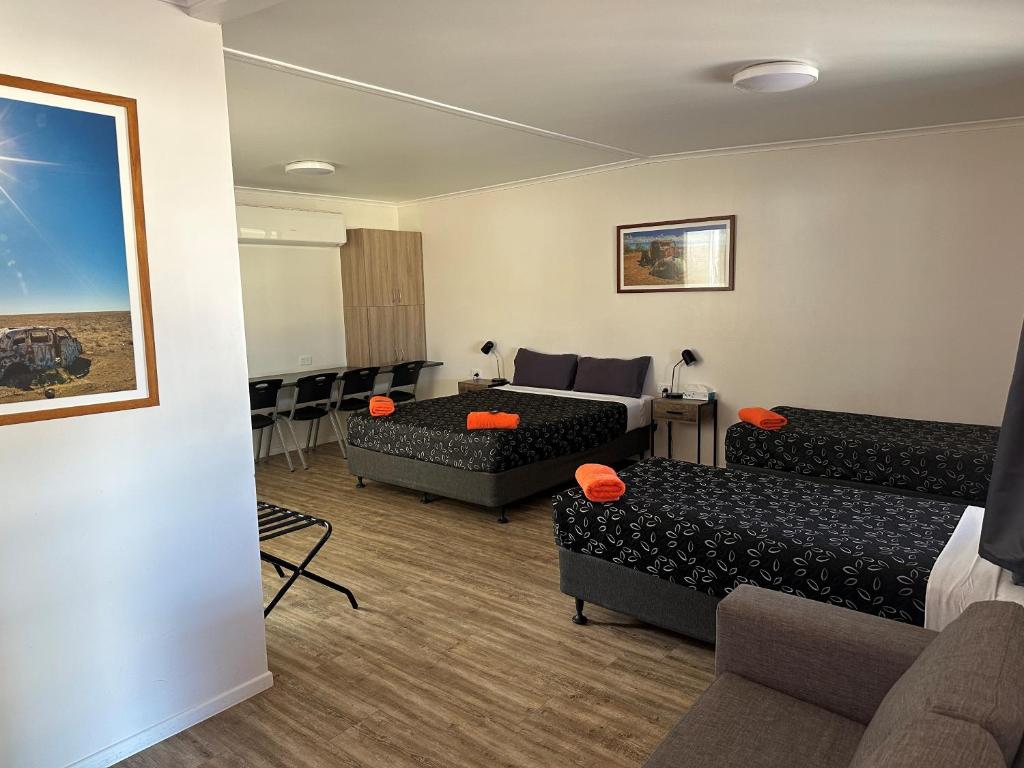 Habitación con sala de estar con sofá y mesa. en Winton Outback Motel en Winton