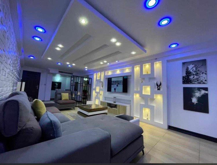 a living room with a couch and a tv at Luxurious B in Lagos