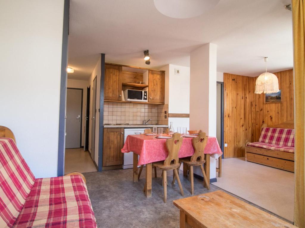 eine Küche und ein Esszimmer mit einem Tisch und Stühlen in der Unterkunft Appartement Lanslebourg-Mont-Cenis, 2 pièces, 4 personnes - FR-1-508-71 in Lanslebourg-Mont-Cenis