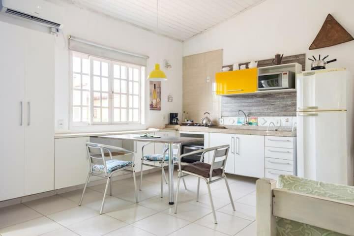 布希奧斯的住宿－LOFT Luz Solar Buzios，厨房配有桌椅和冰箱。