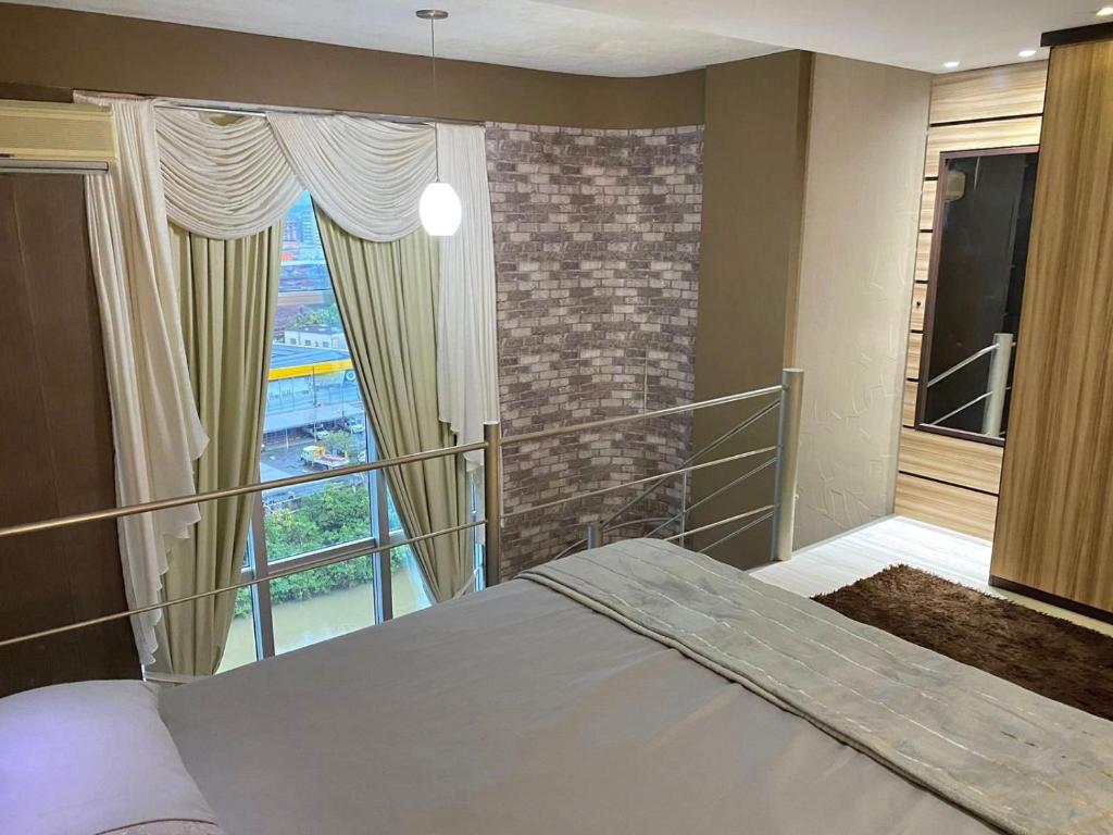 a bedroom with a bed and a large window at Saint Sebastian Flat 612 - Com Hidro! até 4 pessoas, Duplex, no centro in Jaraguá do Sul