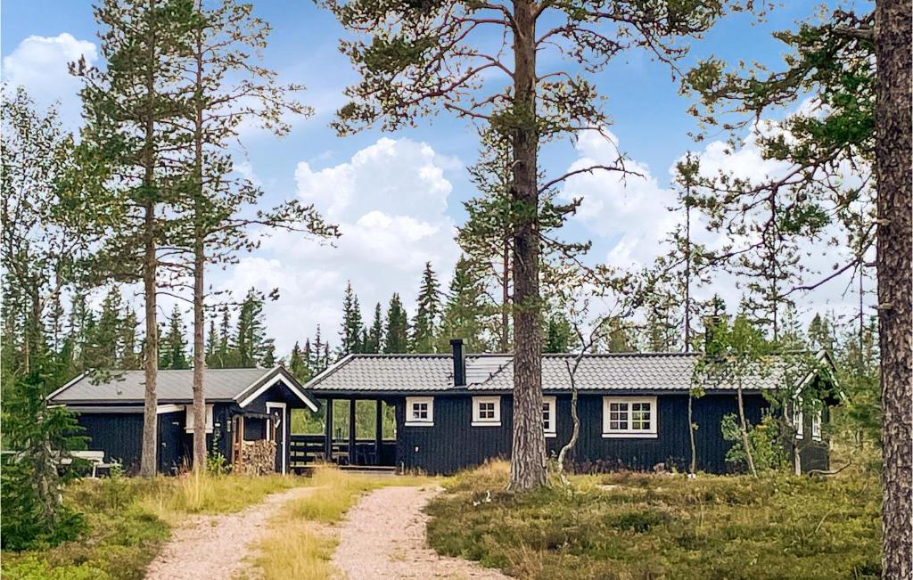 a blue house in the middle of a forest at Pet Friendly Home In stby With Wifi in Østby