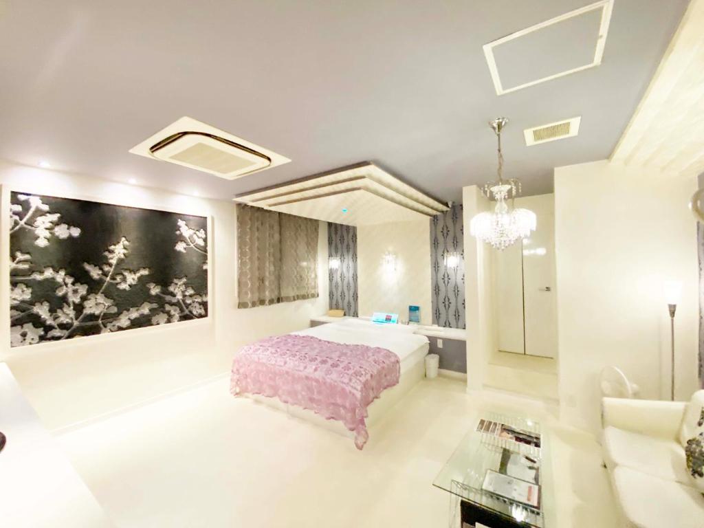 1 dormitorio con 1 cama y una gran pintura en la pared en YOL, en Saijo
