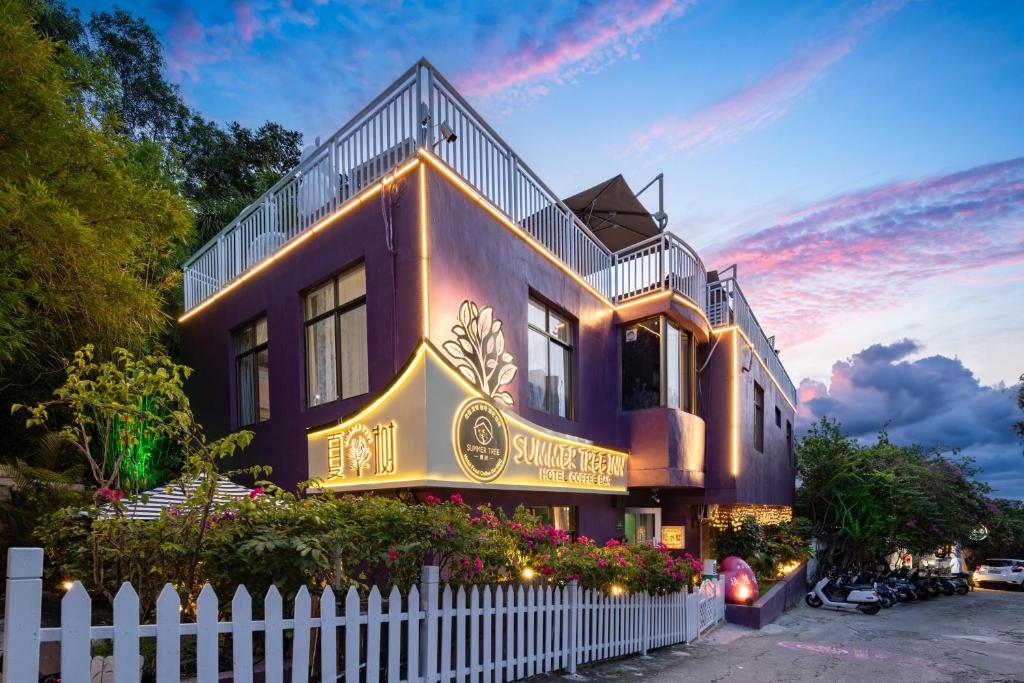 a house with a white fence in front of it at Summer Tree Inn (The Captain's Hostel) in Sanya