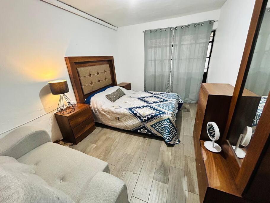 1 dormitorio con cama y sofá en Cómoda casa con dos cuartos y cochera para auto pequeño, en Guadalajara