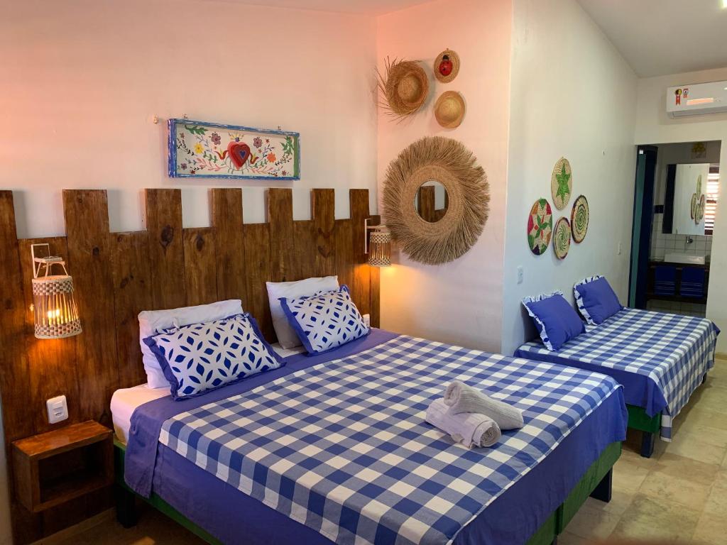 1 dormitorio con 2 camas en azul y blanco en Maria Flor Pousada, en Taíba