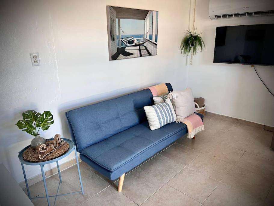 a blue couch in a living room with a table at Rota- Casa Carmen Culebra in Culebra